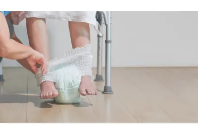 Image d'une personne agée mettant une couche 