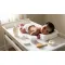 Image d'un Un moment de change avec un bébé et des produits d’hygiène sur une table à langer